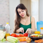 beautiful woman cooking vegetarian salad